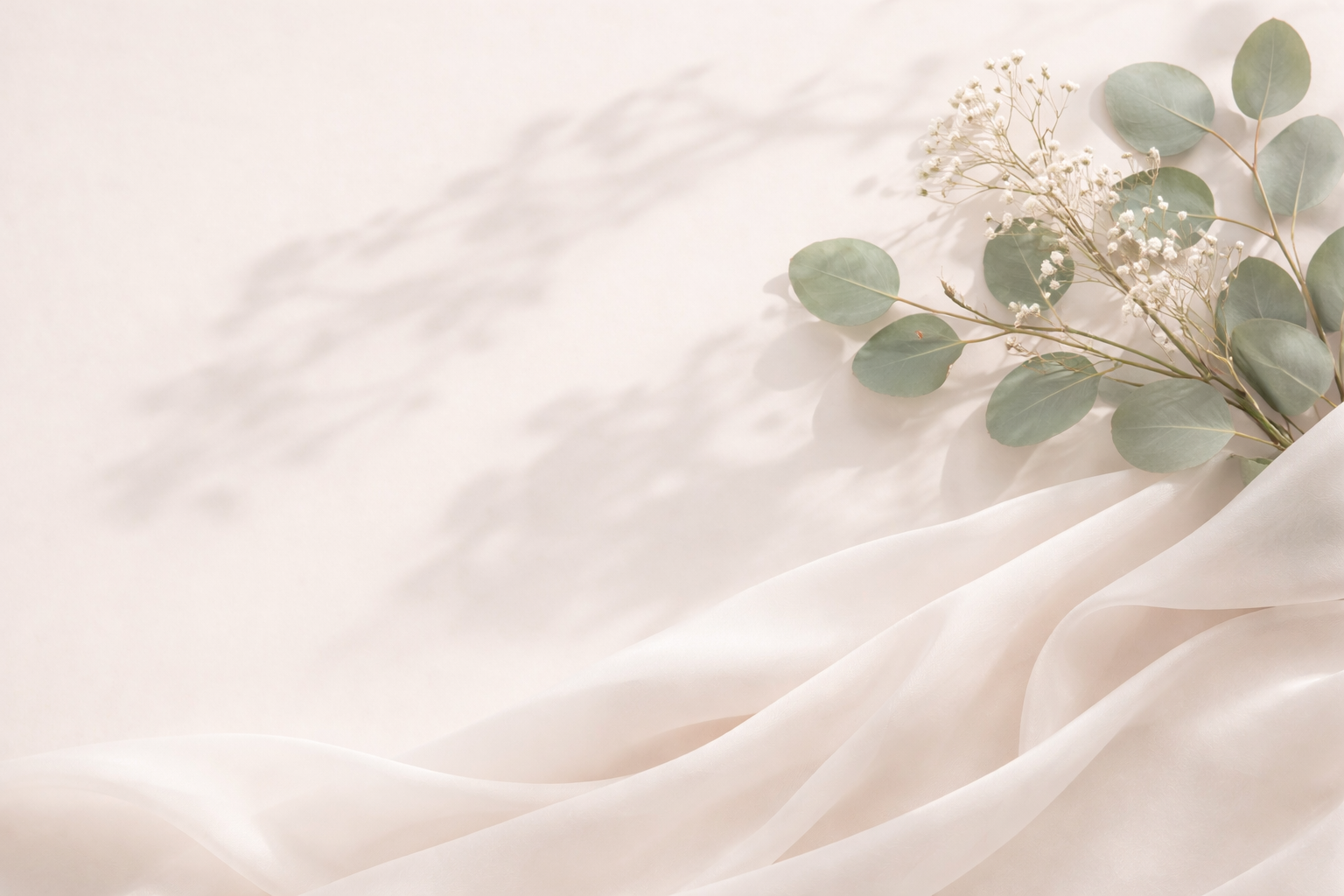 Silky fabric with a branch of eucalyptus leaves on a light background as a hero image from Veya Botanica luxury flower store